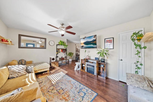 living room featuring dark wood-type flooring and ceiling fan