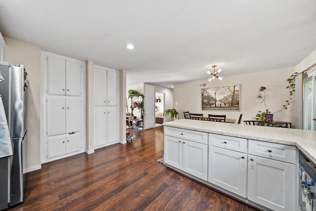 kitchen featuring stainless steel fridge, dark hardwood / wood-style floors, white cabinets, and an inviting chandelier