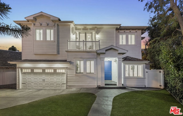 italianate-style house with a garage, a balcony, and a yard