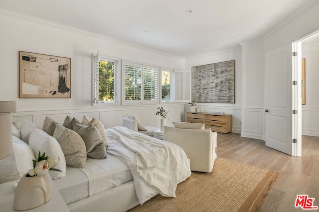 bedroom with ornamental molding and light wood-type flooring