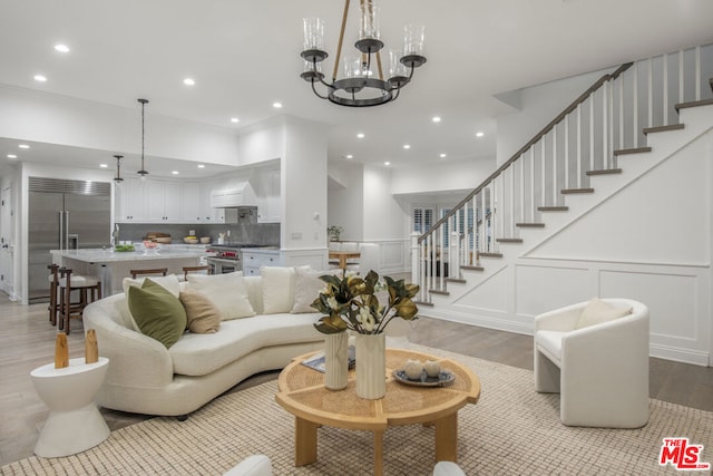 living room with light wood-type flooring and a chandelier