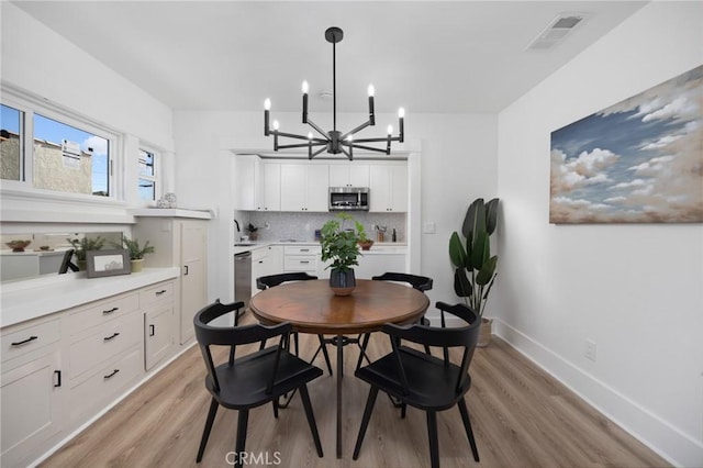 dining space featuring a notable chandelier and light hardwood / wood-style floors