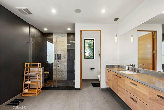 bathroom with a shower with door, vanity, and toilet