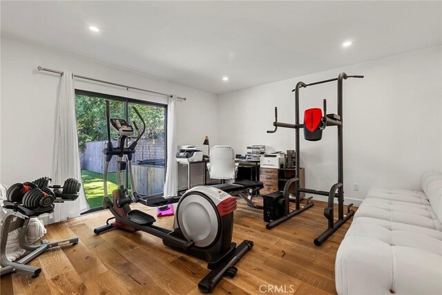 exercise room with light hardwood / wood-style floors