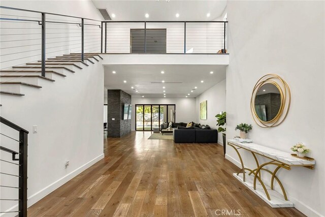 foyer entrance with wood-type flooring and a high ceiling