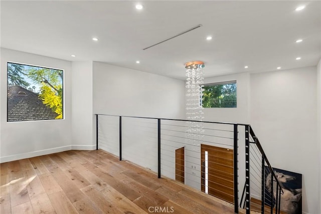 unfurnished room featuring light wood-type flooring and a notable chandelier