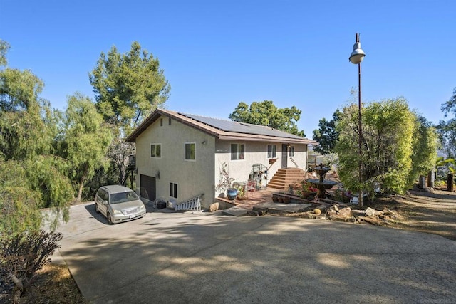 view of side of property featuring a garage and solar panels