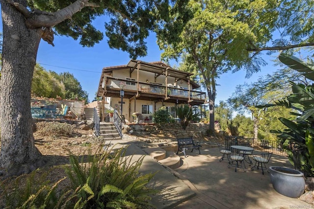 back of property featuring a wooden deck and a patio area