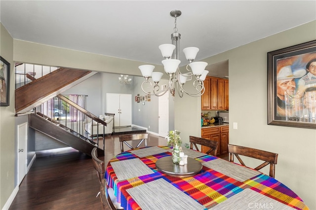 dining area with dark wood-type flooring and a notable chandelier