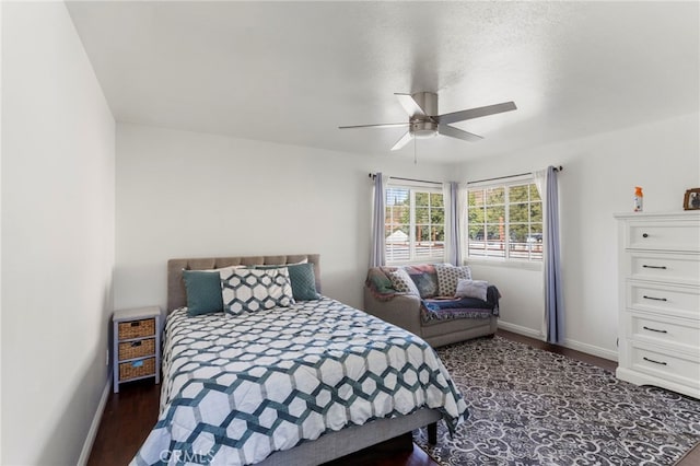 bedroom featuring ceiling fan, dark hardwood / wood-style flooring, and a textured ceiling