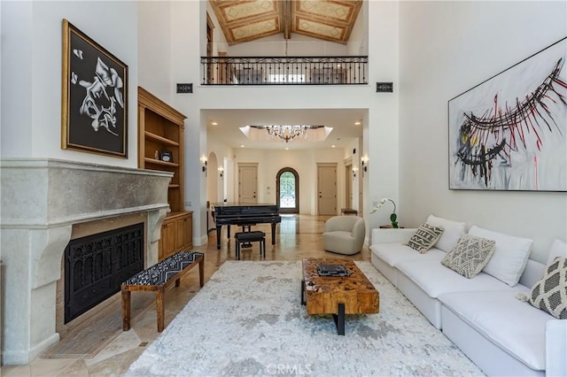 living room featuring an inviting chandelier, a fireplace with flush hearth, and high vaulted ceiling