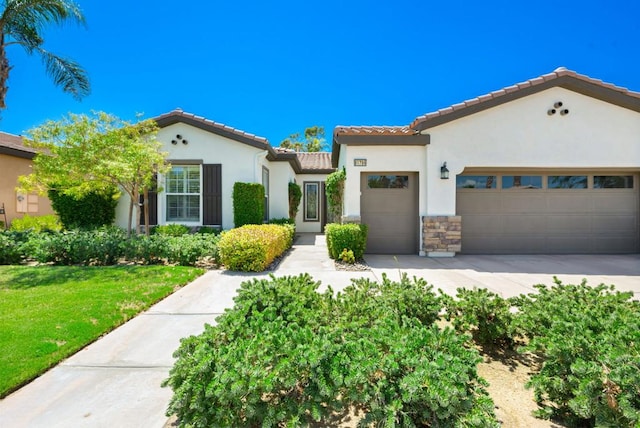 mediterranean / spanish-style home featuring a garage and a front yard