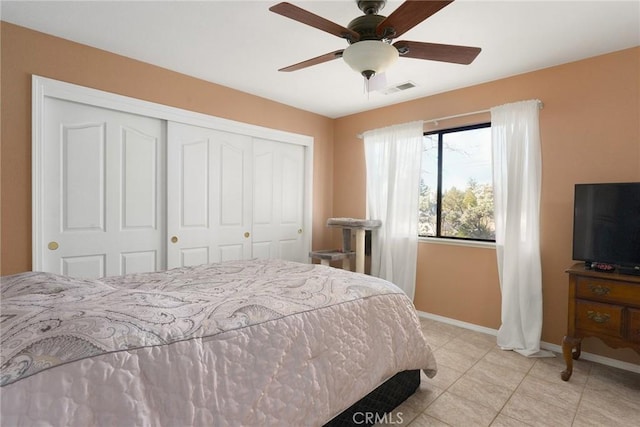 bedroom with ceiling fan, a closet, and light tile patterned floors