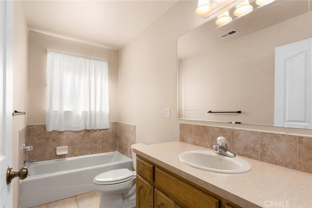 bathroom with tasteful backsplash, a tub to relax in, vanity, toilet, and tile patterned floors