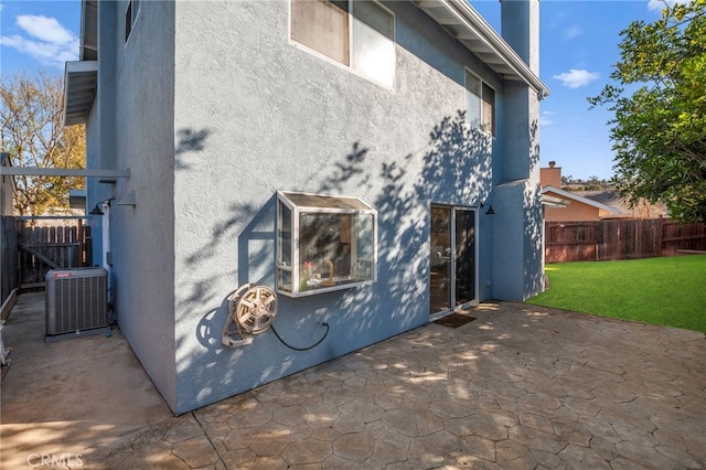 view of property exterior with a patio, a yard, and central AC unit