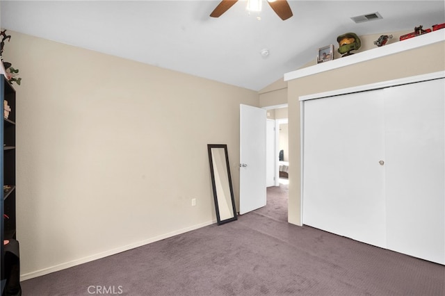 unfurnished bedroom featuring lofted ceiling, a closet, ceiling fan, and carpet flooring