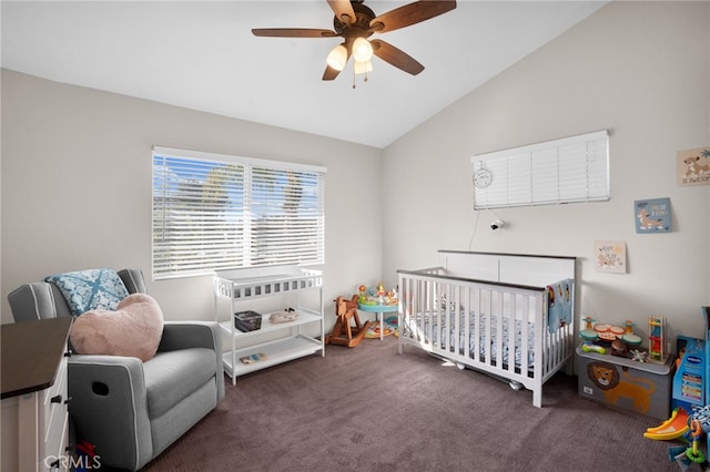 carpeted bedroom featuring a nursery area, ceiling fan, and vaulted ceiling