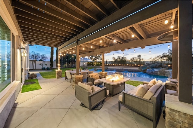 patio terrace at dusk with an outdoor living space with a fire pit