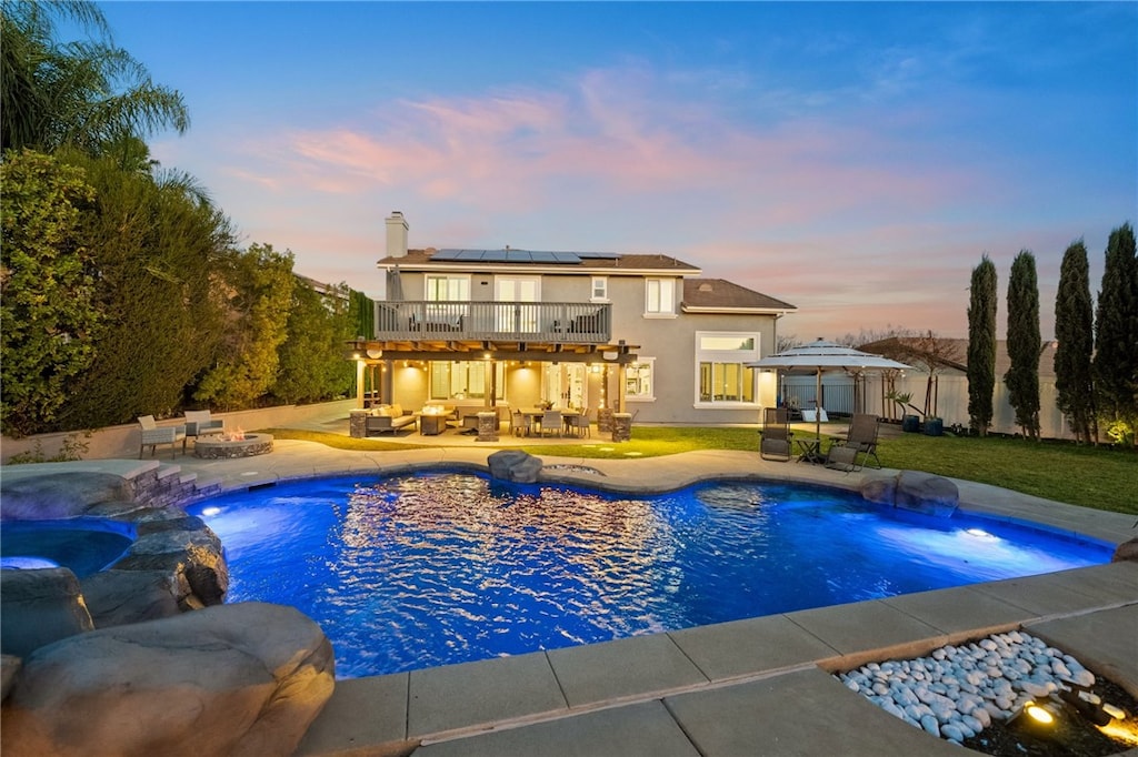 pool at dusk featuring a gazebo, an outdoor living space, and a patio