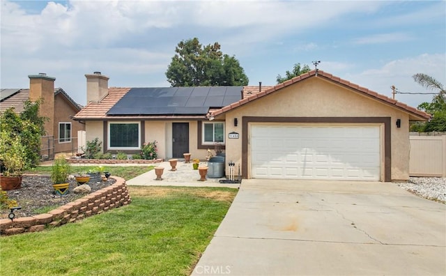 single story home with a garage, a front lawn, and solar panels