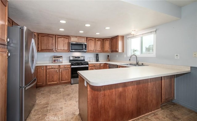 kitchen featuring stainless steel appliances, kitchen peninsula, and sink