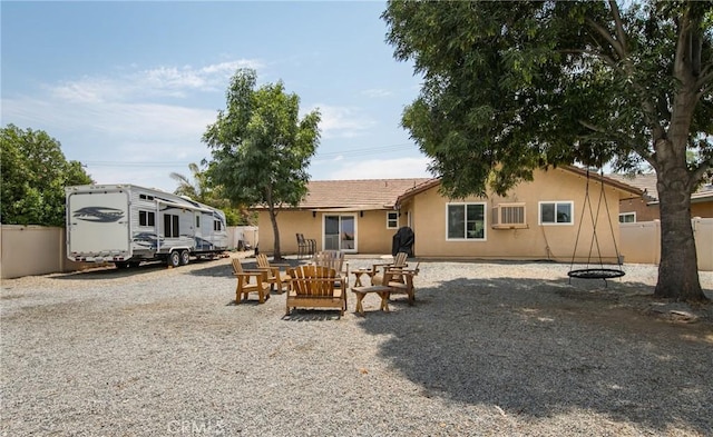 rear view of house with an outdoor fire pit