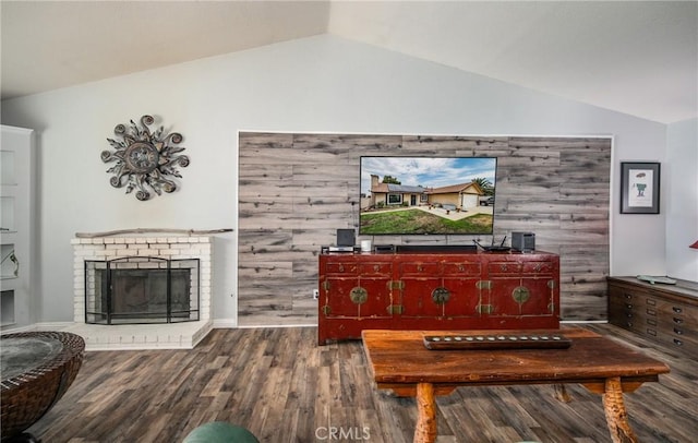 living room with lofted ceiling, hardwood / wood-style floors, a fireplace, and wood walls