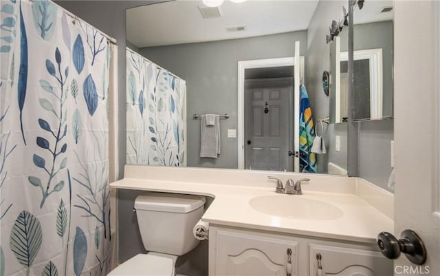 bathroom featuring vanity, curtained shower, and toilet