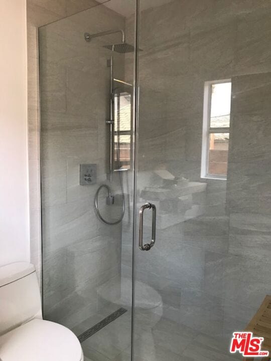 bathroom featuring an enclosed shower and toilet