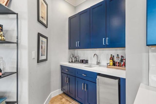 bar with blue cabinetry, beverage cooler, sink, and light tile patterned floors