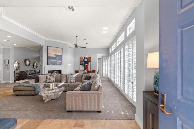 carpeted living room with crown molding, a fireplace, and ceiling fan