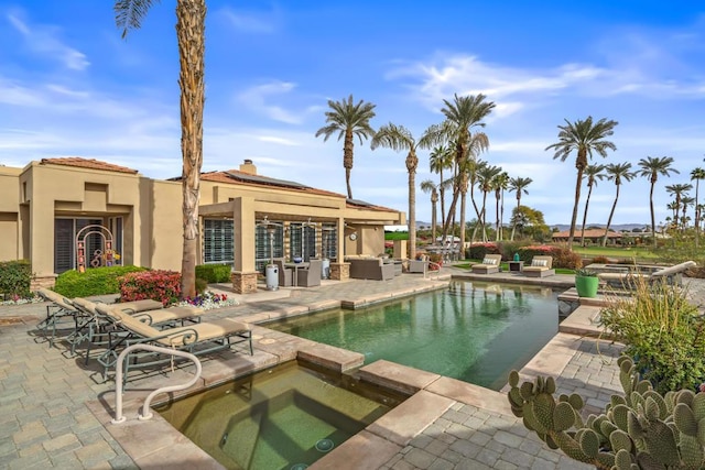 view of pool with an in ground hot tub, outdoor lounge area, and a patio area