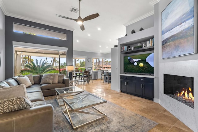 living room featuring crown molding, built in features, and ceiling fan