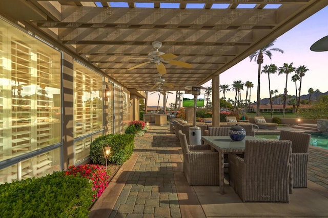 patio terrace at dusk featuring a pergola, a hot tub, and ceiling fan