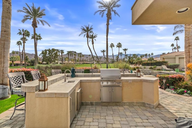 view of patio with a grill, a wet bar, and an outdoor kitchen