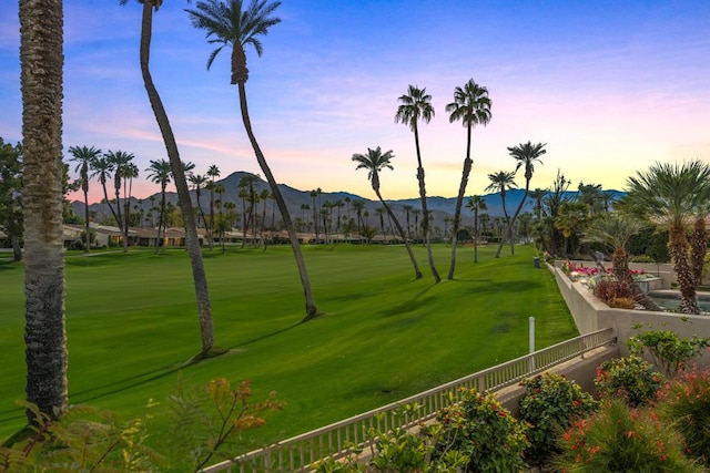 surrounding community with a mountain view and a lawn