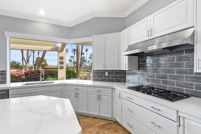 kitchen featuring sink, ornamental molding, white cabinets, stainless steel gas stovetop, and backsplash