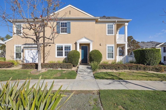 view of front of home with a balcony and a front lawn