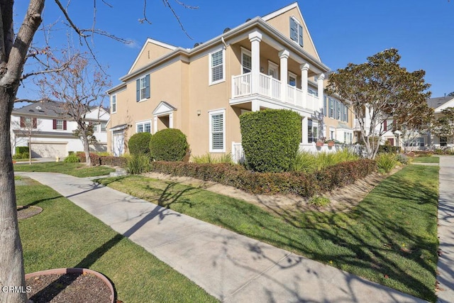 view of home's exterior featuring a balcony, a yard, and a garage