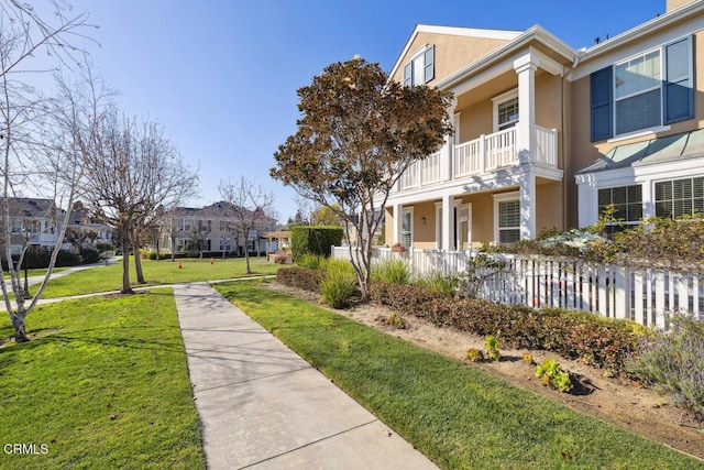 view of home's community with a water view and a lawn