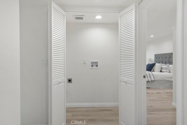 laundry room featuring hookup for an electric dryer, light hardwood / wood-style floors, and hookup for a washing machine