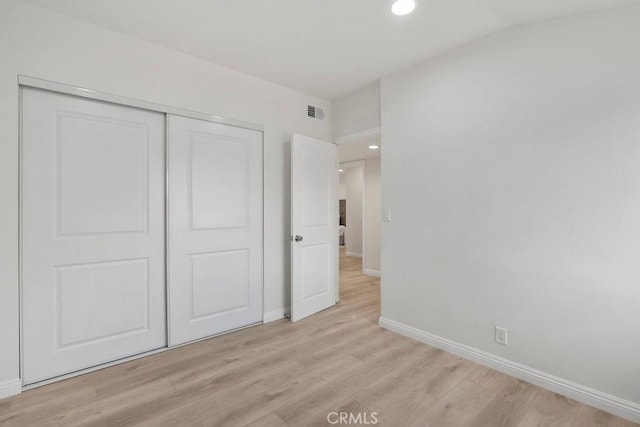 unfurnished bedroom with a closet and light wood-type flooring