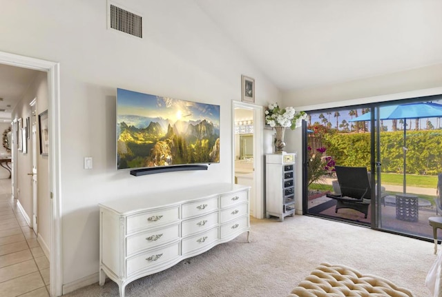 living area with light colored carpet and high vaulted ceiling