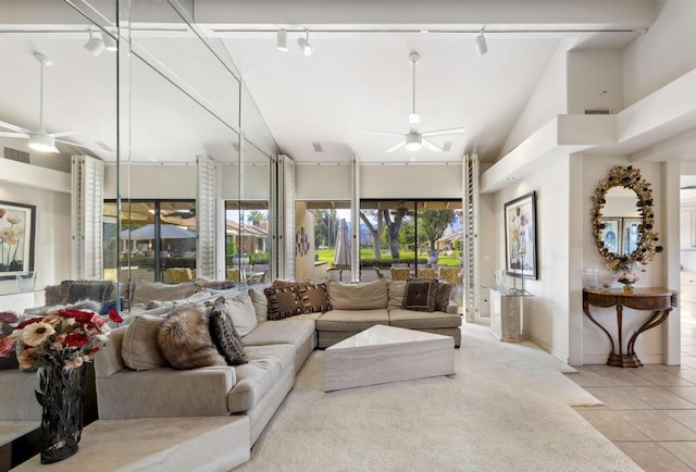 living room with light tile patterned flooring, ceiling fan, and a high ceiling