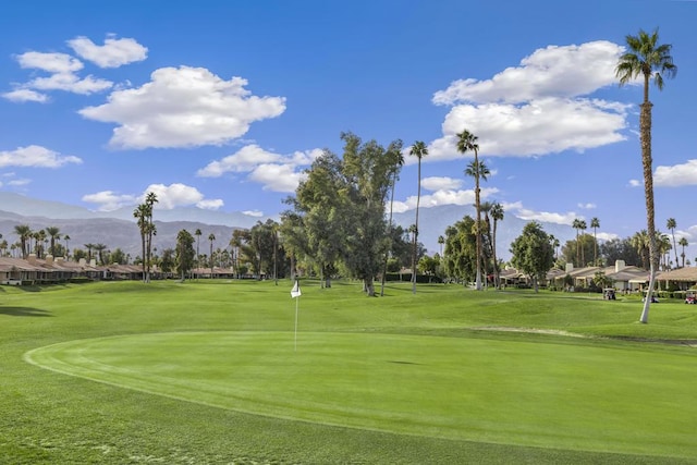 view of property's community with a mountain view and a lawn