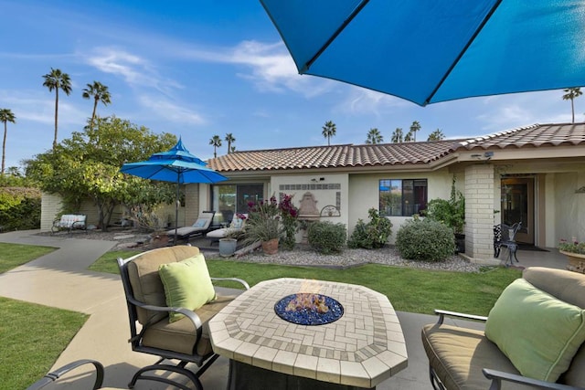 view of patio with an outdoor living space with a fire pit