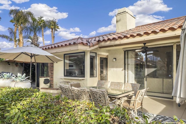 back of property with ceiling fan and a patio area