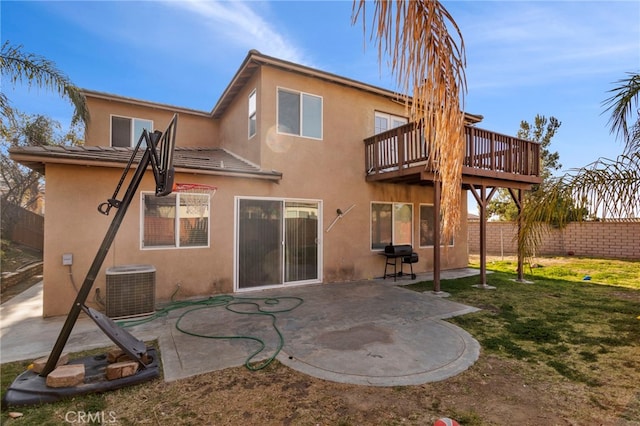 back of property with cooling unit, a wooden deck, a yard, and a patio area