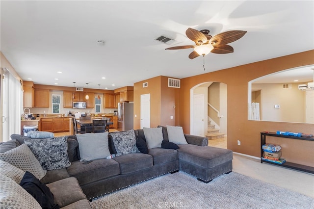 living room featuring light carpet and ceiling fan