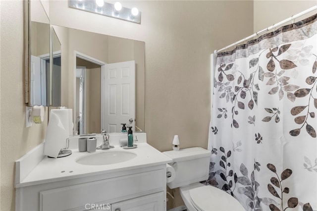 bathroom featuring vanity, toilet, and walk in shower